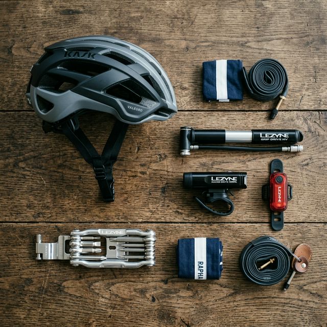 Vue de dessus sur table en bois avec casque, pompe, lumières et outils vélo